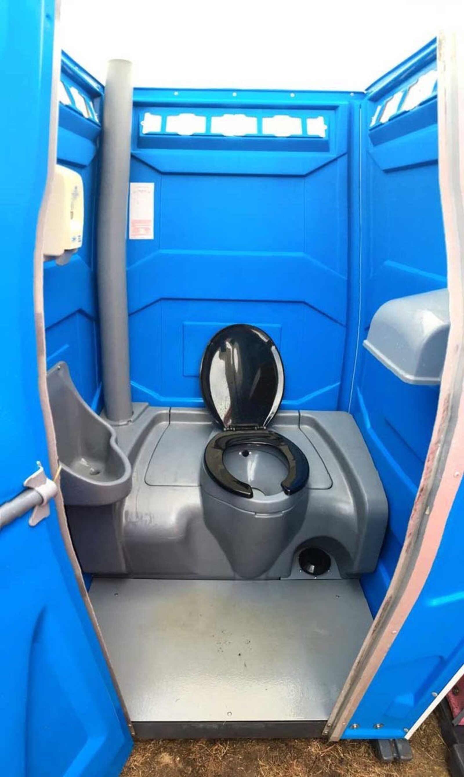Construction worker beside a jobsite portable toilet